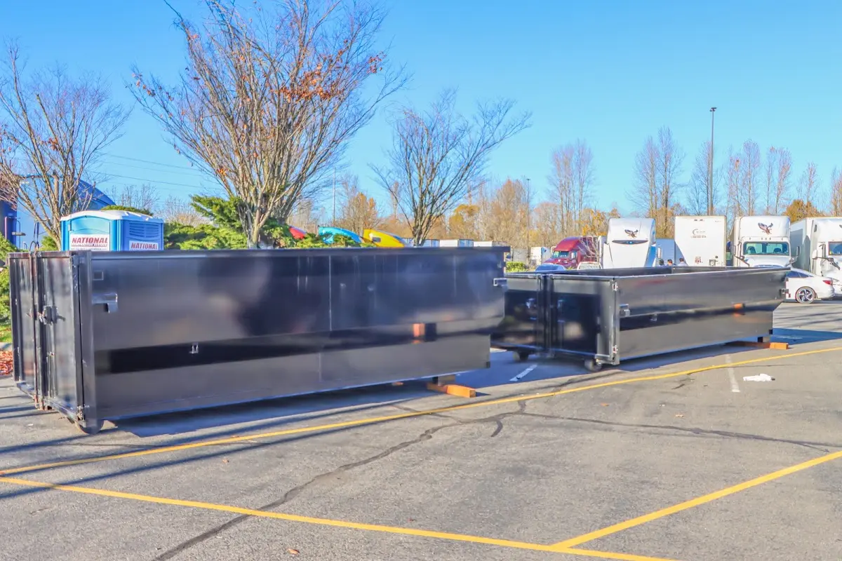 Professional dumpster rental service with roll-off container on residential driveway in New Burlington
